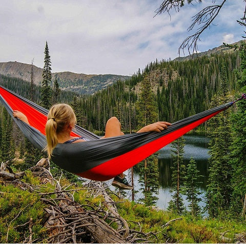 Iemand die heerlijk aan het geniet is van de natuur vanuit de hangmat. Dit heeft ze te danken aan alle bomen die in de ongerepte natuur staan.